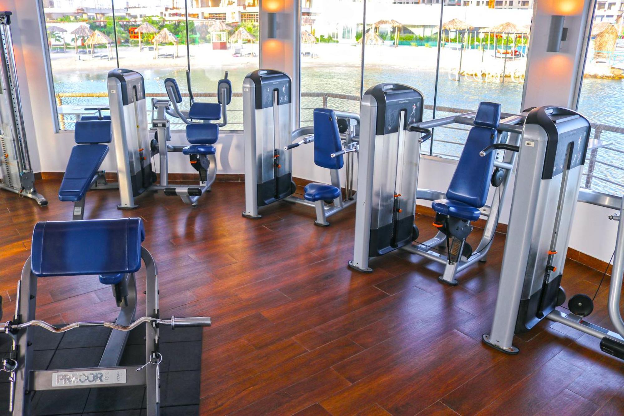 Lagoona Beach Luxury Resort And Spa Al Manamah Esterno foto The photo shows a gym or fitness center with several pieces of exercise equipment. There are multiple machines designed for strength training, including seated machines with padded seats and backrests. The equipment appears to have a modern design an